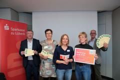 Frank Schumacher (Sparkasse Lübeck), Martha Deegen (Aranat), Verena Bohl (biff), Daniela Lückel (Frauen*notruf), Senator Sven Schindler (v.l.) präsentieren text us.
